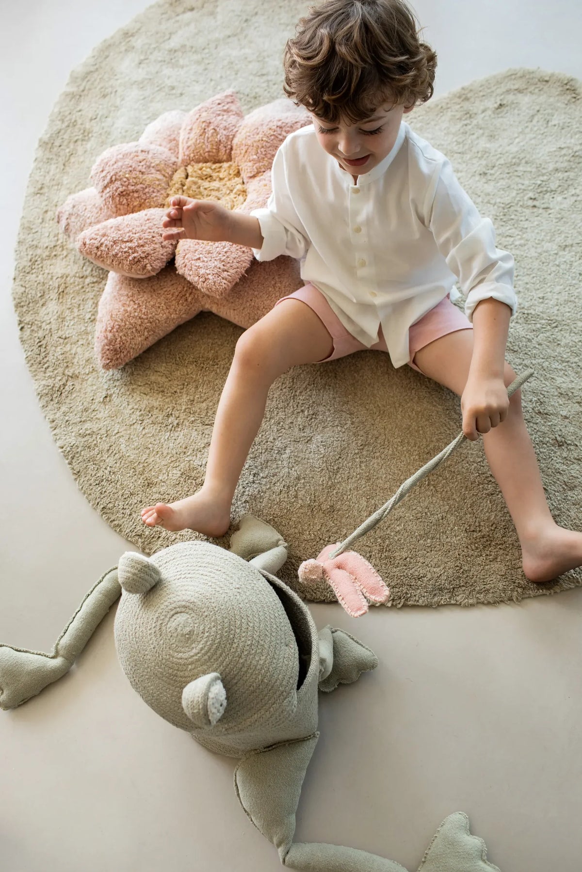 Child playing on Lorena Canals rug with soft decor